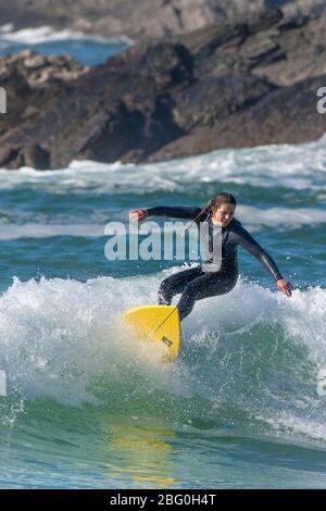 Une femelle à surfer une vague de Fistral Newquay en Cornouailles. Banque D'Images