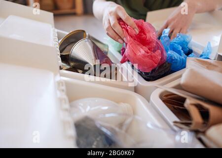 Gros plan sur une femme non reconnaissable mettant un sac en plastique jeté dans la poubelle tout en triant les déchets à la maison, espace de copie Banque D'Images