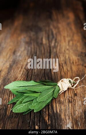 la botte de sauge applique des herbes sur une table en bois - fond Banque D'Images