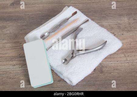 Un ensemble d'outils pour manucure sur une serviette blanche. Soin des ongles, procédure, salon de manucure. Brucelles, coupe-fils, poussoir, bâton orange pour arbres, ciseaux, lime à ongles Banque D'Images