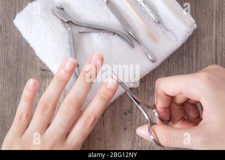 Tondez les ongles sur la main. Faites-vous une manucure. Raccourcir les clous longs. Soins à domicile, spa, beauté. Outils de manucure sur une serviette blanche. Procédure, clou Banque D'Images