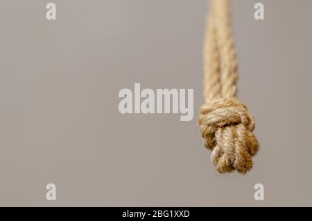 Corde de jute pendante de dessus avec noeuds. Corde avec nœuds rugueux dans une perspective de recul. Le concept de s'efforcer de mieux ou d'atteindre un objectif. Banque D'Images