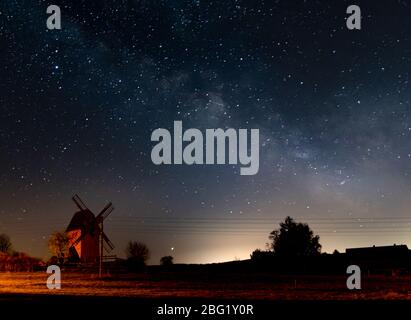 voie lactée dans le ciel de nuit au-dessus du moulin à vent de la Haute Lusace. Pollution lumineuse d'une ferme de tomates à Bogatynia, Pologne Banque D'Images