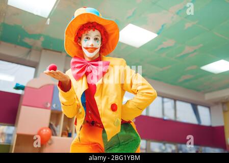 Drôle de pose clown avec nez rouge dans la main Banque D'Images