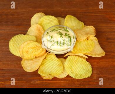Chips de pommes de terre et sauce, sur fond de bois Banque D'Images
