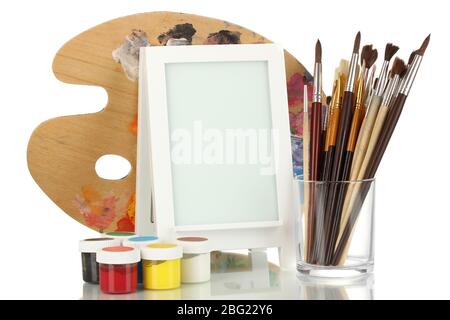 Cadre photo comme chevalet avec les outils de l'artiste isolés sur blanc Banque D'Images