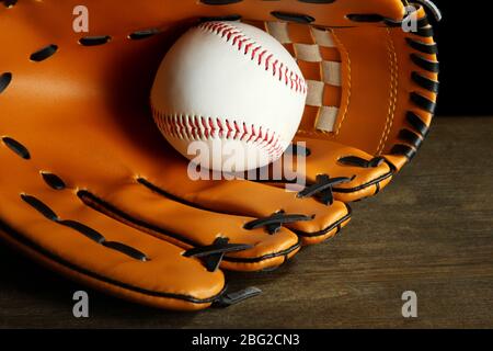 Gant de baseball et balle sur fond sombre Banque D'Images