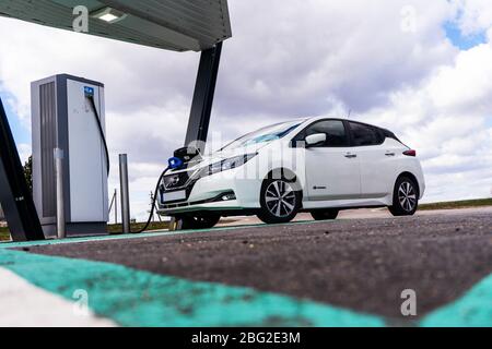 Point de charge de voiture électrique avec Nissan Leaf connecté. Station de parking et de recharge pour véhicules électriques. Banque D'Images