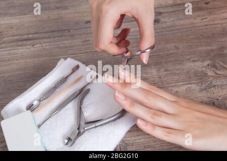 Faites-vous une manucure. Tondez les ongles sur la main. Raccourcir les clous longs. Soins à domicile, spa, beauté. Outils de manucure sur une serviette blanche. Procédure, clou Banque D'Images