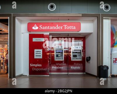 Un guichet automatique en libre-service de marque Santander Totta dans le salon de départ de l'aéroport international de Faro, Portugal. Banque D'Images