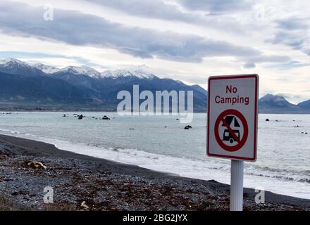 Panneau « pas de camping » le long de l'Esplanade à Kaikoura avec montagnes et plage en toile de fond Banque D'Images