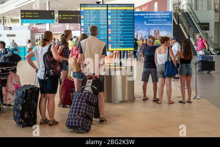 Les touristes vérifiant les informations de départ et d'arrivée à l'aéroport international de Faro. Banque D'Images