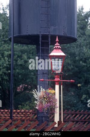 Ancienne lampe de station devant le réservoir d'eau de la gare d'Oxenhope sur le patrimoine Keighley et Worth Valley Railway, West Yorkshire, Angleterre Banque D'Images