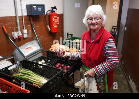 20 avril 2020, Berlin: Le volontaire Gerda Delbrügge emballe des sacs alimentaires dans un point de distribution LAIB et SEELE dans l'église Saint-Trinité. Pendant environ trois semaines, le Berliner Tafel fournit des sacs alimentaires aux personnes nécessiteuses à la maison. Avant l'apparition du virus corona, environ 50 000 personnes nécessiteuses sont venues aux 45 points de distribution LAIB et SEELE de Berlin chaque mois; 42 points de distribution ont cessé leurs opérations précédentes. Certains volontaires des 42 points de distribution continuent à collecter des aliments ou à livrer les sacs pré-emballés aux portes avant de leurs clients, d'autres les distribuent à indiv Banque D'Images