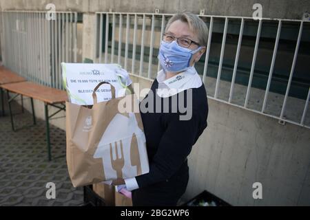 20 avril 2020, Berlin: Sabine Werth, présidente et fondatrice de Berliner Tafel e.V., détient le 10 000 e sac alimentaire entre ses mains. Depuis environ trois semaines, Berliner Tafel fournit des sacs alimentaires aux personnes nécessiteuses à la maison. Avant l'apparition du virus corona, environ 50 000 personnes nécessiteuses sont venues aux 45 points de distribution LAIB et SEELE de Berlin chaque mois; 42 points de distribution ont cessé leurs opérations précédentes. Certains volontaires des 42 points de distribution continuent à collecter des aliments ou à livrer les sacs pré-emballés aux portes avant de leurs clients, d'autres les distribuent à l'individu n Banque D'Images