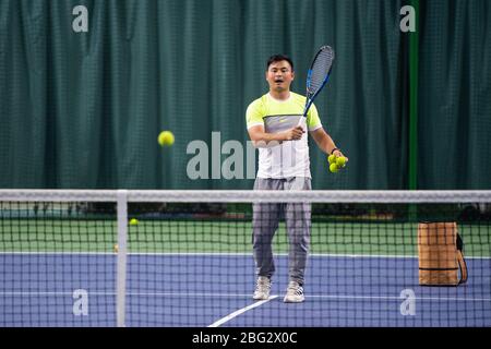 Changsha, province chinoise de Hunan. 20 avril 2020. Un entraîneur de tennis sert pendant un cours d'entraînement dans un centre sportif Changsha, province du Hunan en Chine méridionale, le 20 avril 2020. Crédit: Chen Sihan/Xinhua/Alay Live News Banque D'Images