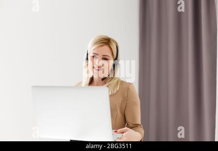 Une femme gaie porte un casque rire en utilisant la vidéo de flux de conférence de l'ordinateur portable enseigner en ligne, heureux ethnique fille élève tuteur ont plaisir regarder le webinaire Banque D'Images