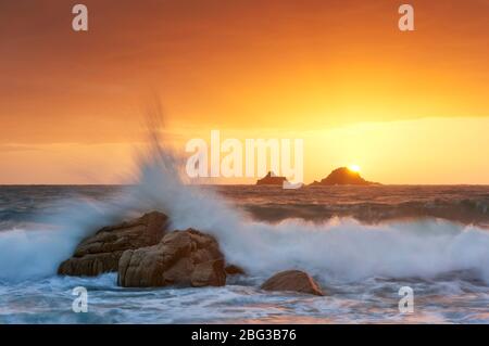 Vagues qui éclaboussent sur les rochers à Porth Nanven, Cornwall Banque D'Images