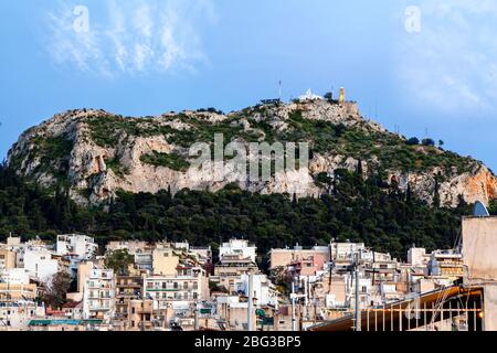 Vue l'après-midi sur la colline de Lycabettus depuis le quartier d'Exarcheia et Neapoli, dans le centre-ville d'Athènes, Grèce. Banque D'Images