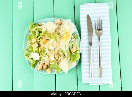 Salade César sur plaque bleue, sur fond en bois couleur Banque D'Images