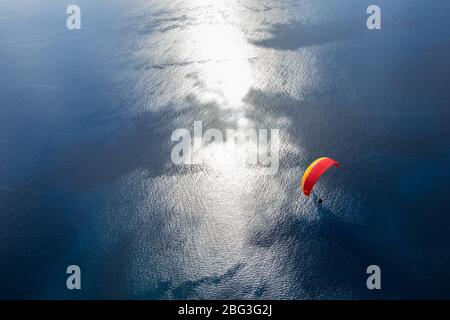 Parapente dans le ciel. Survolez l'océan Atlantique avec de l'eau bleue en journée ensoleillée. Vue aérienne du parapente sur l'île de Madère, Portugal. Banque D'Images