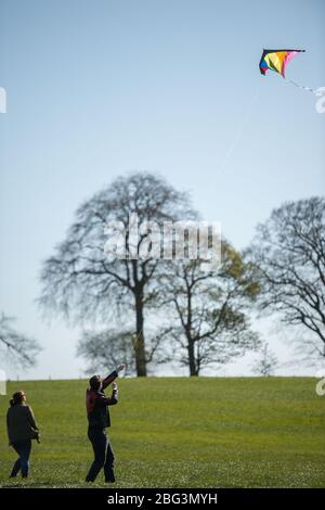 Bishopbriggs, Glasgow, Royaume-Uni. 20 avril 2020. Photo: Rachel et Scott utilisent leur temps d'exercice alloué et profiter d'une belle journée ensoleillée et venteuse pour voler leur cerf-volant. Un ciel bleu et un champ vert font un cadre parfait pour le vol en cerf-volant. Crédit : Colin Fisher/Alay Live News Banque D'Images