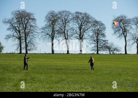 Bishopbriggs, Glasgow, Royaume-Uni. 20 avril 2020. Photo: Rachel et Scott utilisent leur temps d'exercice alloué et profiter d'une belle journée ensoleillée et venteuse pour voler leur cerf-volant. Un ciel bleu et un champ vert font un cadre parfait pour le vol en cerf-volant. Crédit : Colin Fisher/Alay Live News Banque D'Images