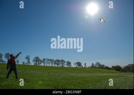 Bishopbriggs, Glasgow, Royaume-Uni. 20 avril 2020. Photo: Rachel et Scott utilisent leur temps d'exercice alloué et profiter d'une belle journée ensoleillée et venteuse pour voler leur cerf-volant. Un ciel bleu et un champ vert font un cadre parfait pour le vol en cerf-volant. Crédit : Colin Fisher/Alay Live News Banque D'Images