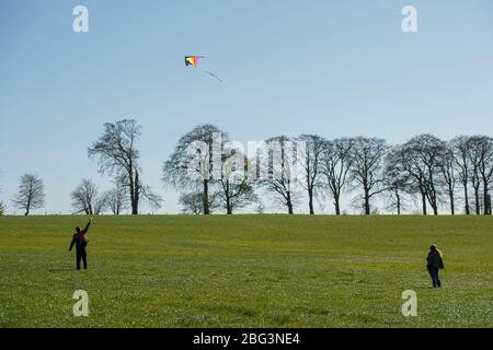 Bishopbriggs, Glasgow, Royaume-Uni. 20 avril 2020. Photo: Rachel et Scott utilisent leur temps d'exercice alloué et profiter d'une belle journée ensoleillée et venteuse pour voler leur cerf-volant. Un ciel bleu et un champ vert font un cadre parfait pour le vol en cerf-volant. Crédit : Colin Fisher/Alay Live News Banque D'Images