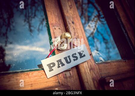 Ancienne porte de magasin avec affiche « Pause » Banque D'Images