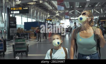 Femme et enfant bébé touriste caucasien à l'aéroport avec porter un masque médical de protection. Famille en quarantaine isolée. Covid-19 de coronavirus. Banque D'Images