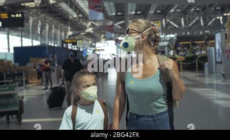 Femme et enfant bébé touriste caucasien à l'aéroport avec porter un masque médical de protection. Famille en quarantaine isolée. Covid-19 de coronavirus. Banque D'Images