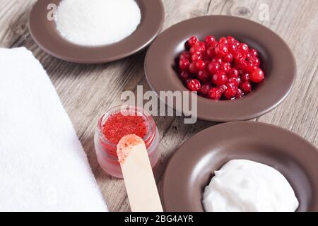 Une femme fait un gommage naturel du corps. Gommage fait maison à base de sucre, sel, crème et baies. Beauté, spa, soins de la peau, aromathérapie. Hydratant, peeling Banque D'Images