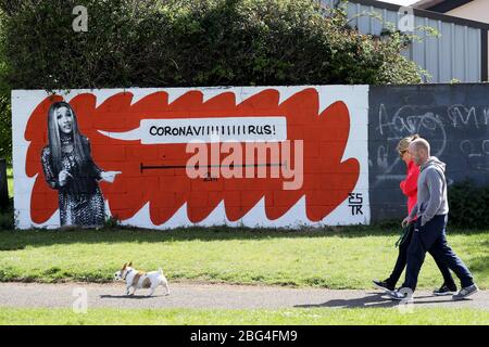 Les gens passent une murale de l'artiste Cardi B par l'artiste irlandais Emmalene Blake dans un parc du sud de Dublin. L'artiste de Dublin a créé une série de peintures murales pour encourager les gens à respecter les règles de distanciation sociale qui comportent des artistes tels que Dua Lipa, Robyn et Cardi B. Banque D'Images