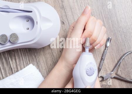 Une femme fait sa propre manucure de matériel à la maison. Gros plan. Kit de manucure. Dangereux. Clous. Soins à domicile, salon, Spa, beauté, santé. Manucure russe Banque D'Images