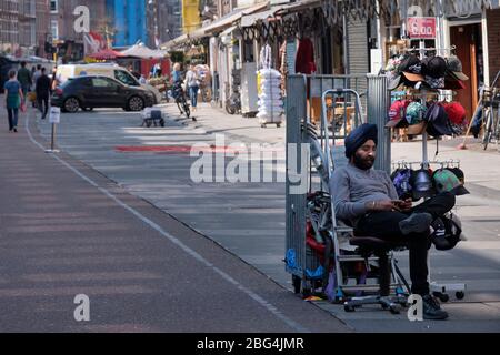 Corona Crisis: Un vendeur solitaire sur le célèbre marché Albert Cuyp à Amsterdam (Pays-Bas). Le marché est partiellement fermé. Banque D'Images