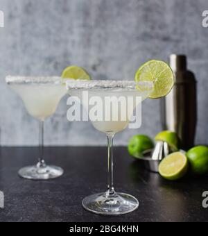 Deux cocktails margarita avec cimes et shaker sur comptoir noir Banque D'Images