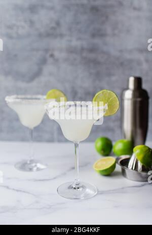 Deux cocktails margarita avec cimes et shaker sur un comptoir en marbre blanc Banque D'Images