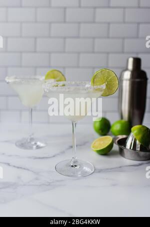Deux cocktails margarita avec cimes et shaker sur un comptoir en marbre blanc Banque D'Images