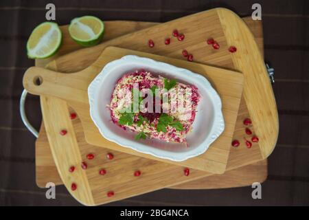 Betterave avec ail et mayonnaise. Salade panaméenne faite de pommes de terre, betteraves, œufs, oignons et mayonnaise . planche en bois Banque D'Images