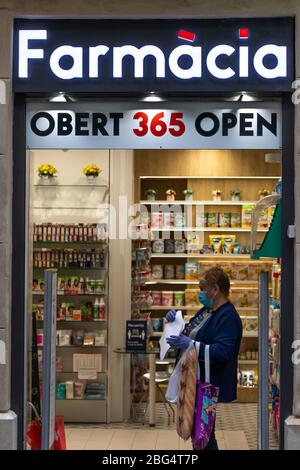 Barcelone, Espagne. 20 avril 2020. Femme portant un masque et faisant la queue pour acheter des médicaments dans une pharmacie à Barcelone Banque D'Images