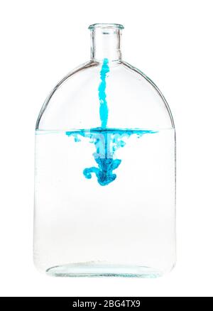 écoulement d'encre bleue dans l'eau dans une fiole en verre isolée sur fond blanc Banque D'Images