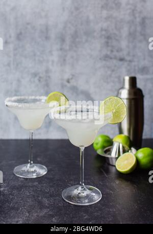 Deux cocktails margarita avec cimes et shaker sur comptoir noir Banque D'Images