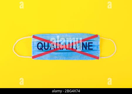Sur le masque médical traverse l'inscription quarantaine avec des bandes rouges sur fond jaune. Concept de quarantaine et d'arrêt de la pandémie de coronavirus. Haut vi Banque D'Images
