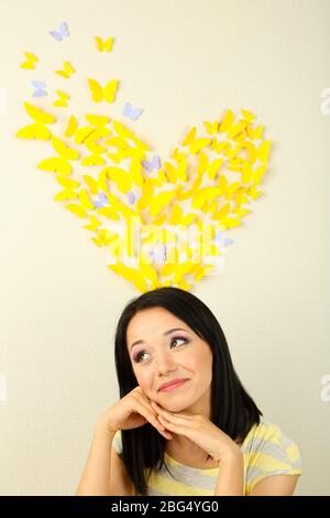 Fille près de papillons en papier voler sur le mur Banque D'Images