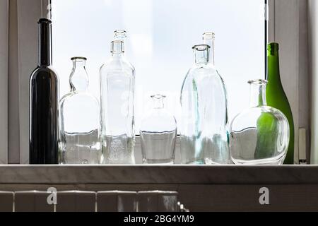 plusieurs bouteilles vides en état d'ivresse sur le seuil de la fenêtre de la maison le jour de la fonte Banque D'Images