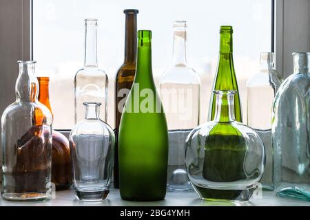 plusieurs bouteilles vides sur le seuil de fenêtre à la maison le jour ensoleillé du printemps Banque D'Images