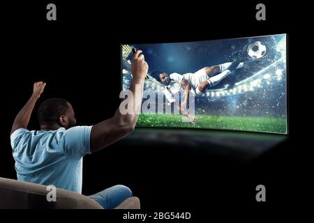 Le Viewer devant une télévision sur le fauteuil à la maison se sent à l'intérieur de l'action Banque D'Images