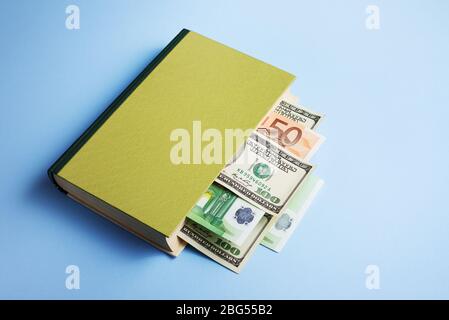 Concept de littératie financière et de gestion de l'argent. Réservez avec un signet sous forme de facture en dollars et en euros Banque D'Images