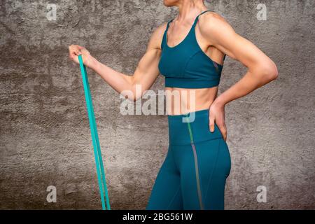 Gros plan sur une femme utilisant un bracelet de résistance pour garder la forme et l'exercice Banque D'Images